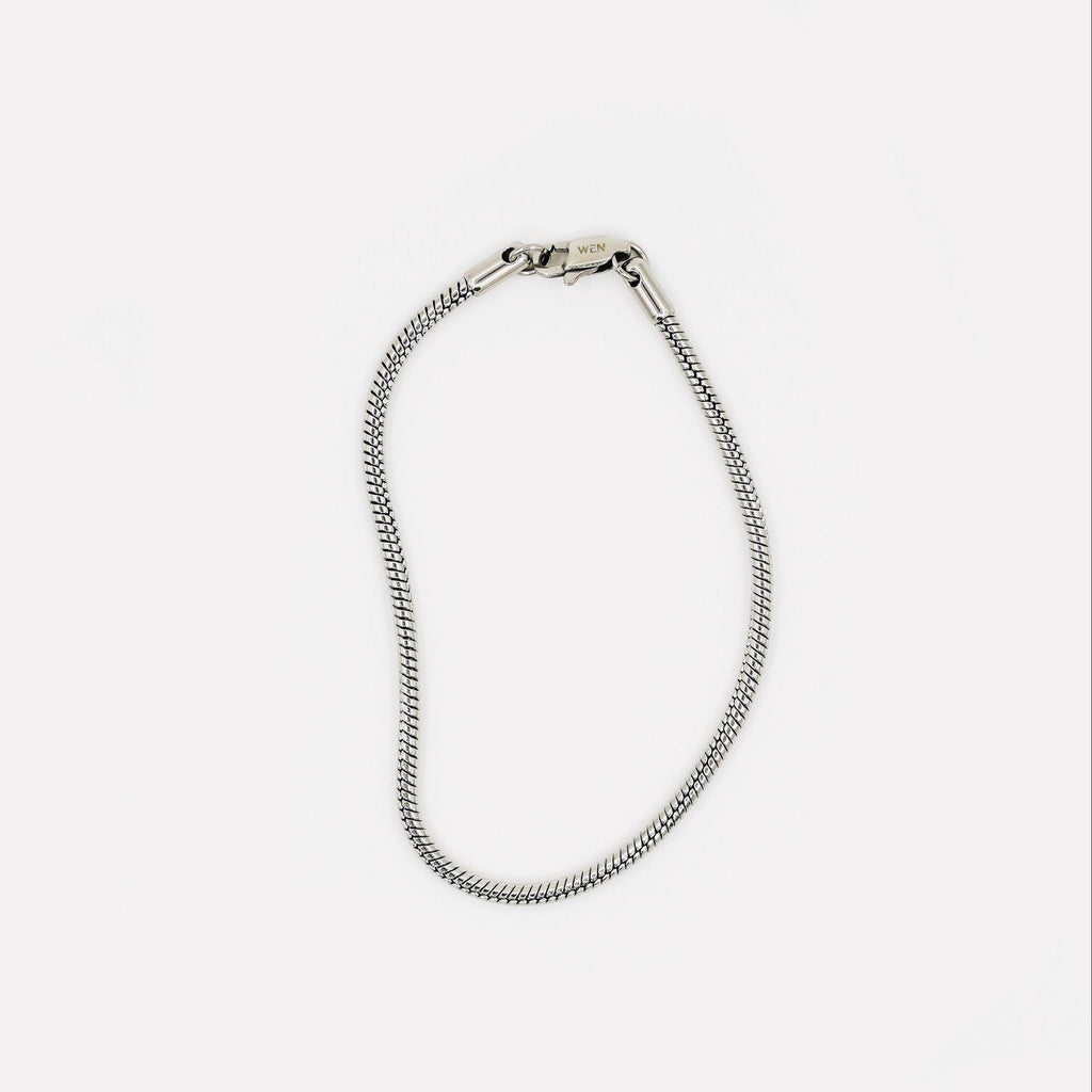 Silver chain bracelet on a light gray background